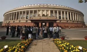 People stand in front of the Indian parliament building on the opening day of the winter session in New Delhi